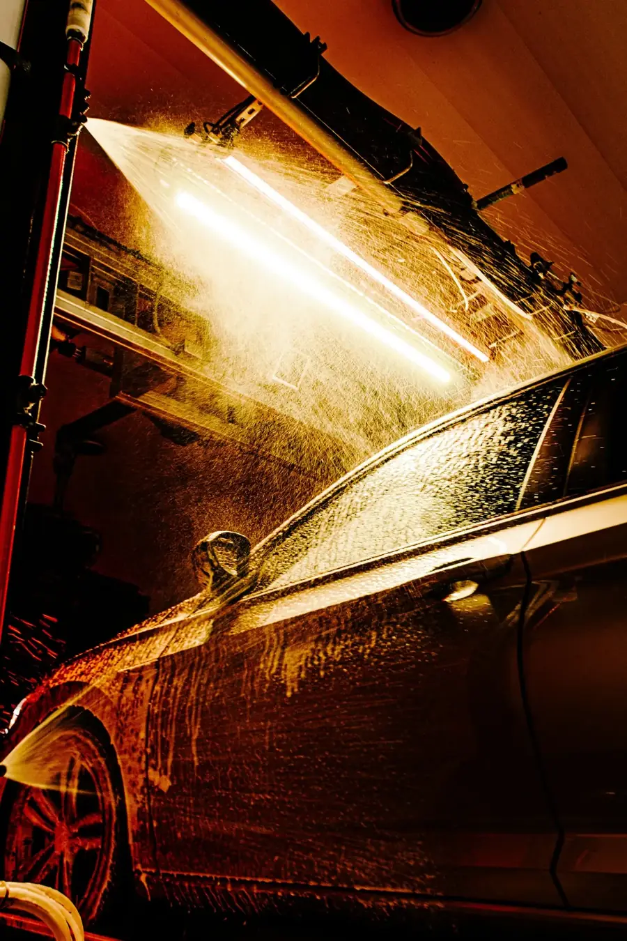 Wasstraat met waterstralen en licht op een wagen